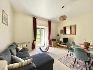 ein Wohnzimmer mit einem blauen Sofa und einem Tisch in der Unterkunft LE MANOIR - REZ DE CHAUSSEE - PARKING - WIFI - CENTRE VILLE in Quimper