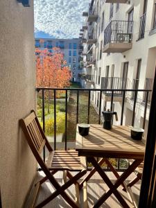 a wooden table and a chair on a balcony at AK Apartments 2 in Warsaw