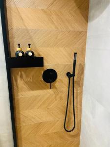 a bathroom with a shower with a hose on a wooden floor at AK Apartments 2 in Warsaw +9 photos