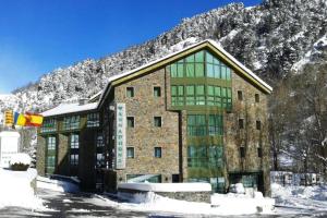 ein großes Gebäude mit Schnee auf einem Berg in der Unterkunft Annapurna M&P in Ordino