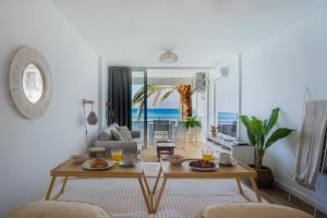 a living room with a table and a view of the ocean at Sobre el mar con vistas a las Dunas de Maspalomas in San Agustin