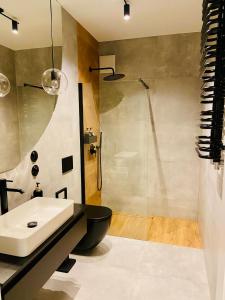 La salle de bains est pourvue d'un lavabo et d'une douche. dans l'établissement AK Apartments 2, à Varsovie
