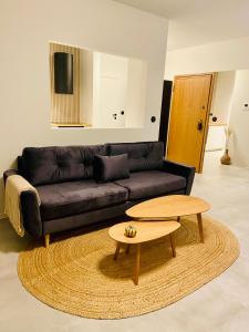 a living room with a black couch and a table at AK Apartments 2 in Warsaw