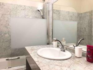 ein Badezimmer mit Waschbecken und Spiegel in der Unterkunft LE MANOIR - REZ DE CHAUSSEE - PARKING - WIFI - CENTRE VILLE in Quimper + 20 Fotos