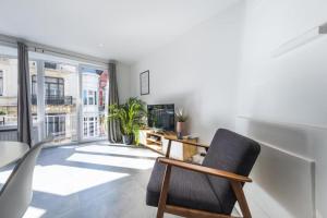 a room with a chair and a table and a window at Luxury apartment with free parking in Ostend