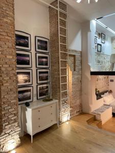 een woonkamer met een bakstenen muur met ingelijste foto's bij AnDiMi, Histórico. in Toledo