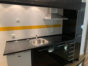 a kitchen with a sink and a stove at AnDiMi, Histórico. in Toledo