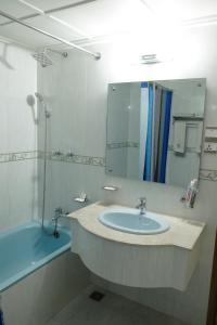 a bathroom with a sink and a mirror and a tub at Hotel Saint Martin Ltd. in Chittagong