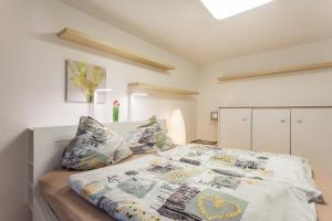a bedroom with a bed with a white bedspread and pillows at Ferienwohnung Zur Quelle in Plettenberg