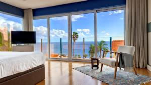 een slaapkamer met een bed en uitzicht op de oceaan bij Villa Madeira by LovelyStay in Caniço