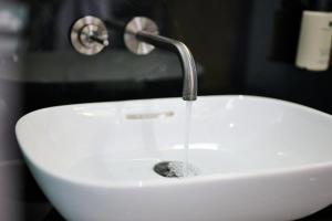 lavabo blanco con grifo en el baño en The Halyard Liverpool, Vignette Collection, an IHG Hotel, en Liverpool