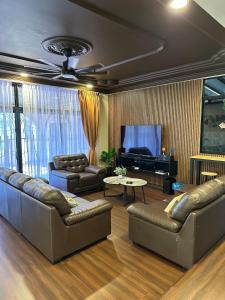 a living room with couches and a piano at Villamax Klebang Beach Homestay Melaka 25 Pax 6R4B in Melaka