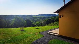 a building with a view of a green field and trees at Cabanas Vinsanto in Bento Gonçalves