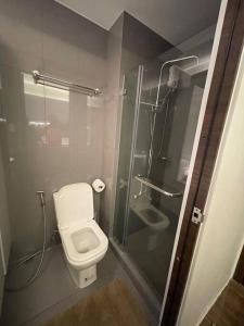 La salle de bains est pourvue de toilettes et d'une douche en verre. dans l'établissement Cozy Family Nook at Makati, à Manille