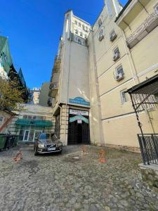 un'auto parcheggiata di fronte a un edificio con una torre dell'orologio di Andreevskiy mini-hotel a Kiev