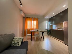 a living room with a couch and a table in a kitchen at DownTown View Modern Apartment in Tirana