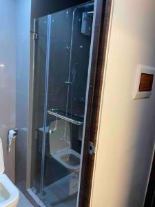 La salle de bains est pourvue d'une douche en verre et de toilettes. dans l'établissement Cozy Family Nook at Makati, à Manille