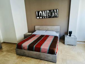 パレルモにあるGaia Apartmentのベッドルーム(ベッド1台付)とロンドンを読むサイン
