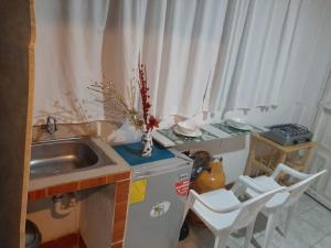 cocina con fregadero y mesa con sillas en Estudio en Garzota con Cocina y lavanderia Wifi, en Guayaquil
