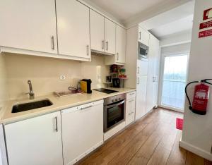 a kitchen with white cabinets and a sink at LINDA PRAIA in Consolação +20 photos
