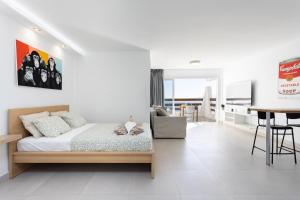 a bedroom with a bed and a dining room at Home2Book Stylish Studio Ocean View Tabaiba in Tabaiba