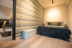 1 dormitorio con cama y pared en Sonrisa, en Knokke-Heist