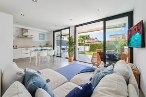 a living room with a large couch and a kitchen at Js Villas rental Ap La Perla 5 Puerto Pollensa in Port de Pollensa