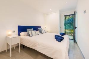 a white bedroom with a large bed and a window at Js Villas rental Ap La Perla 5 Puerto Pollensa in Port de Pollensa +12 photos