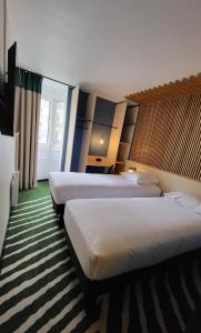 ジョアンヴィル・ル・ポンにあるHotel Joinville Hippodromeのベッド2台と窓が備わるホテルルームです。