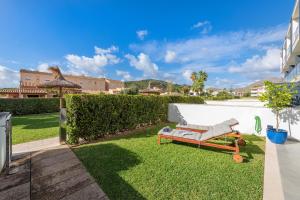 a couch sitting on the grass in a yard at Js Villas rental Ap La Perla 5 Puerto Pollensa in Port de Pollensa