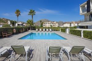 a villa with a swimming pool and lounge chairs at Js Villas rental Ap La Perla 5 Puerto Pollensa in Port de Pollensa