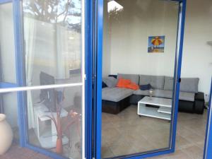 a living room with a couch and a glass door at Ferienwohnung Wellenblick in Trassenheide