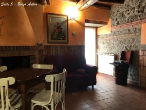 una sala da pranzo con tavolo e divano di Albergo Diffuso Locanda Specchio Di Diana a Nemi