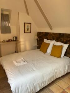 a bedroom with a large white bed with yellow pillows at LIVING'Melun, la campagne à Melun ! in Melun