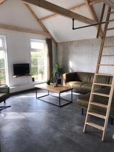 een woonkamer met een bank en een ladder bij Vakantiehuis voor 4 personen in Opheusden