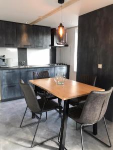 a kitchen with a wooden table and some chairs at Vakantiehuis voor 4 personen in Opheusden
