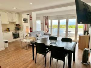 a kitchen and living room with a table and chairs at LINDA PRAIA in Consolação