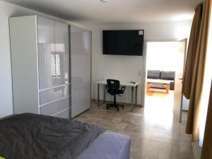 sypialnia z łóżkiem, biurkiem i telewizorem w obiekcie Ferienwohnung und Zimmer zum Donaublick w mieście Kelheim