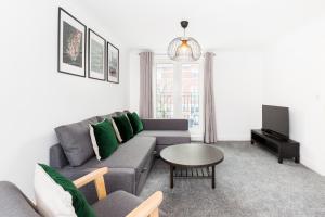 バーミンガムにあるNewly Renovated - 4 Bedroom Anchor House - Close to JQ, Birmingham City Centre - Groups & Contractorsのリビングルーム(ソファ、テーブル付)