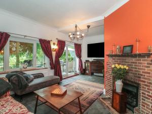 Una sala de estar con un sofá y una chimenea. en Brook Farm, en Ringwood