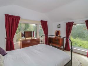 a bedroom with a bed and a desk and a window at Brook Farm in Ringwood