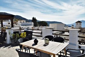 une table et des chaises en bois sur le toit dans l'établissement Hotel Rural Alfajía de Antonio, à Capileira