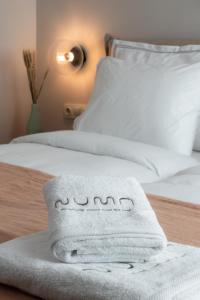 a white towel sitting on top of a bed at Numa Suites & Lofts Athens in Athens