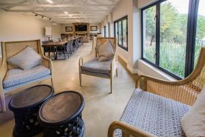 a waiting room with chairs and a table and windows at Valley Lodge - Babanango Game Reserve in Glückstadt