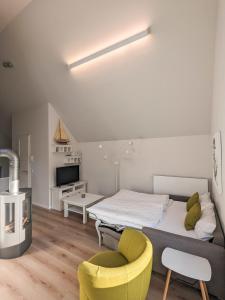 ハイリゲンハーフェンにあるOstsee - Appartement Nr 87 "Kapitäns Koje" im Strand Resortのベッドルーム1室(ベッド1台、黄色い椅子付)
