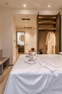 Cama blanca grande en habitación con armario en Nicolas Centrale-Smart City Suites, en Igoumenitsa