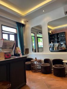 um restaurante com um bar com bancos e um espelho em Petit Espace Boutique Hostel em Vientiane