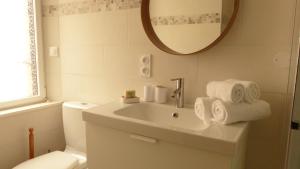 a bathroom with a sink and a toilet and a mirror at Douillette maison de ville à Carnac in Carnac +23 photos