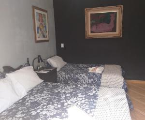 a bedroom with two beds and a picture on the wall at Hostel Suite Home in Saquarema
