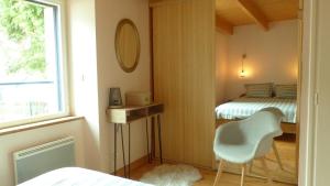 a bedroom with a bed and a chair and a window at Douillette maison de ville à Carnac in Carnac